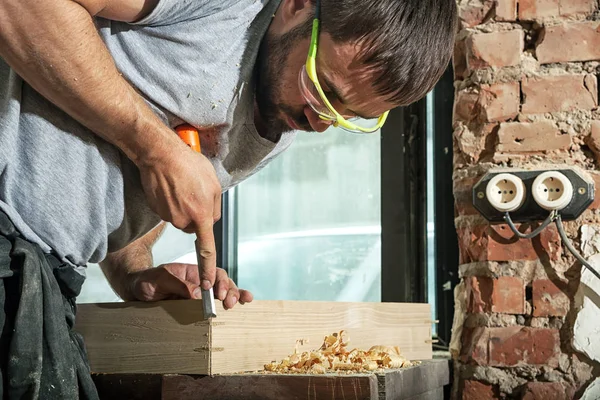 Hombre tratando un producto de madera con un cincel — Foto de Stock