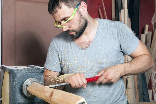 Мужчина делает деревянное изделие на токарном станке — стоковое фото