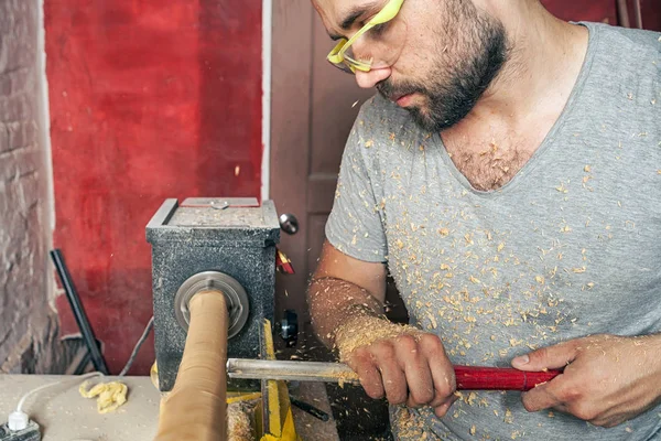 Hombre hace un producto de madera en un torno — Foto de Stock