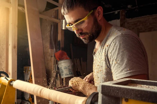 Costruttore gestisce il legno su un tornio — Foto Stock