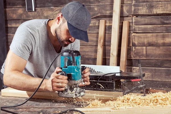 Homem bordas de madeira com uma máquina de moagem — Fotografia de Stock