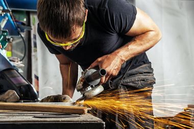 adam bir açı öğütücü ile metal taşlama 