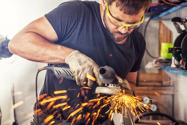 Homem processa metal um moedor de ângulo — Fotografia de Stock