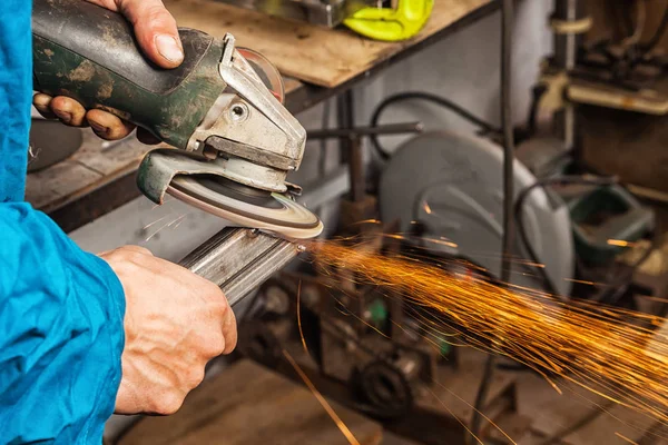 Mannen svetsare grinder metall en vinkelslip — Stockfoto