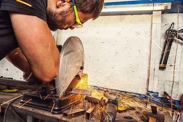 Mannen svetsare skär en metall med en cirkelsåg — Stockfoto