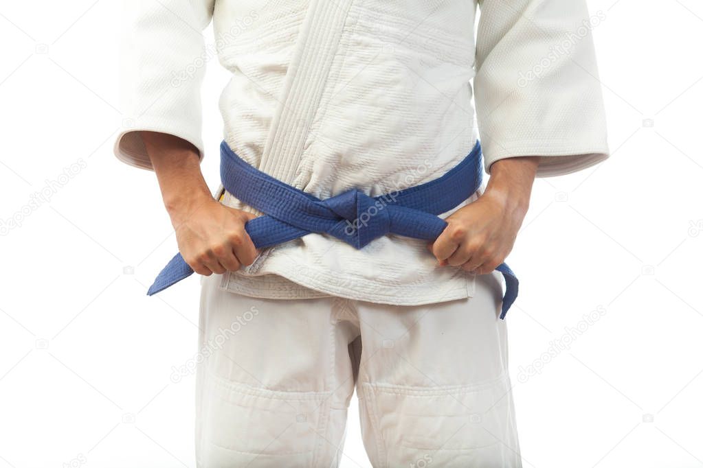 Close-up of a man  in a white kimono for judo, ties up a blue be
