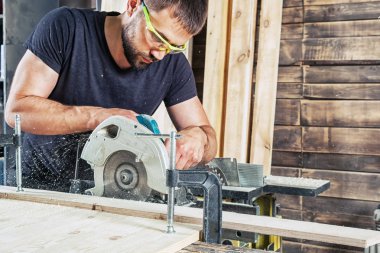   man sawing wooden with a modern circular saw  clipart