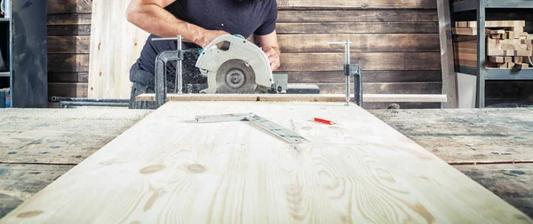 Hombre aserrando madera con una sierra circular moderna — Foto de Stock