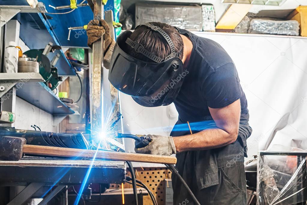 man welds with a welding machine metal