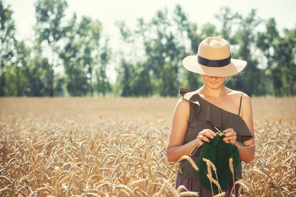 Молода жінка в'язалася на пшеничному полі — стокове фото