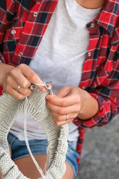 Jovem mulher tricota uma camisola — Fotografia de Stock