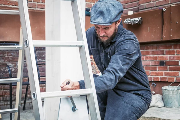 L'uomo stringe dadi metallici con una chiave — Foto Stock