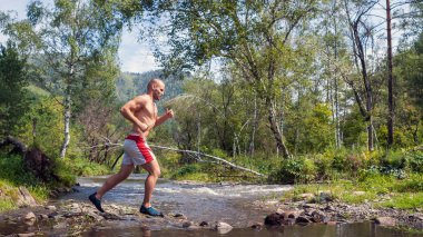 Runner atlet dağ nehir geçiyor