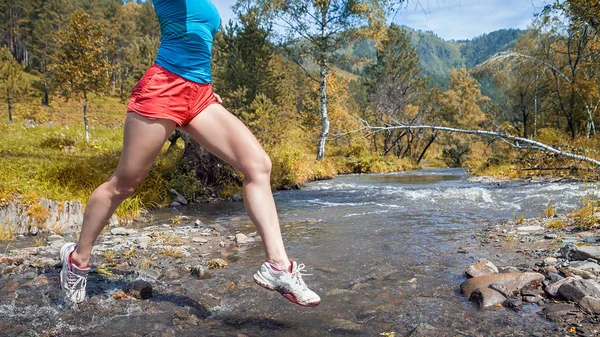 woman runner jumping over  river