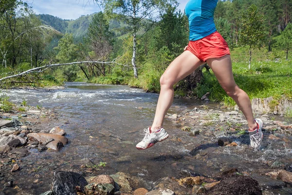 woman runner jumping over  river