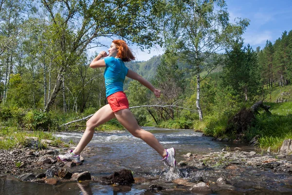 woman runs down a mountain river