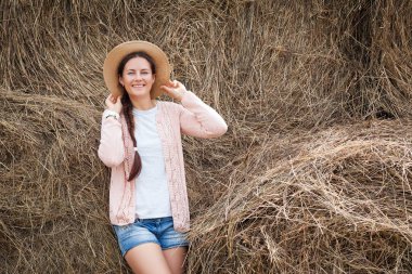 kadın bir saman yığını karşı teşkil etmektedir. 