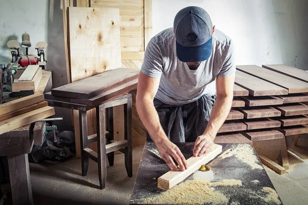 Hombre es igual a una barra de madera con una fresadora —  Fotos de Stock