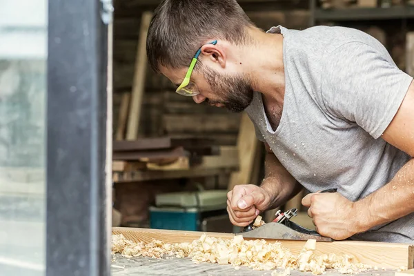 Uomo gestisce un legno con un piano jack nero — Foto Stock