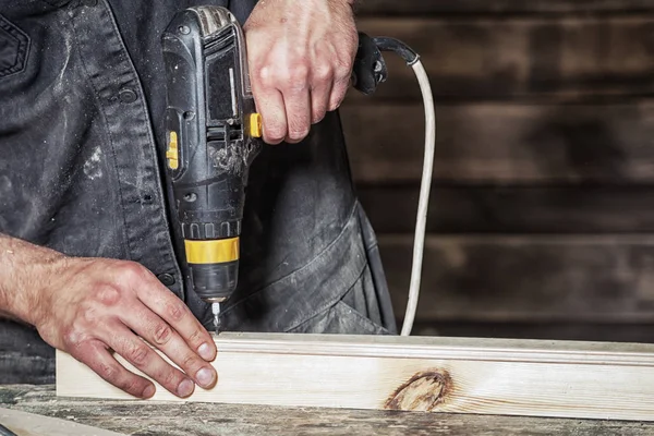 Arbeiter Schraube mit einem schwarzen modernen Schraubendreher — Stockfoto