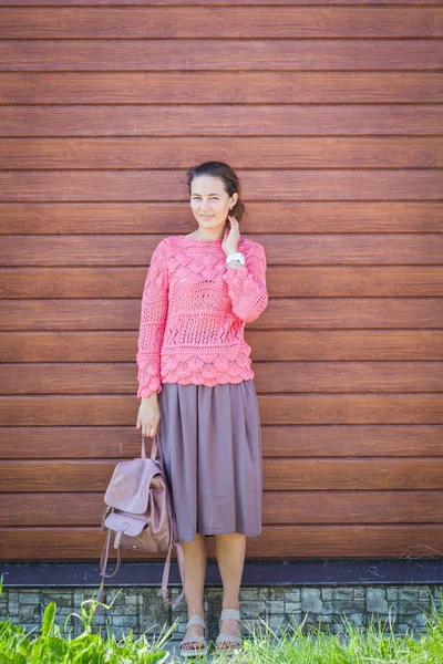 Жінка посміхається і тримає рожевий рюкзак — стокове фото