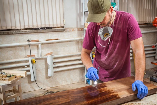 Man pinta uma madeira — Fotografia de Stock