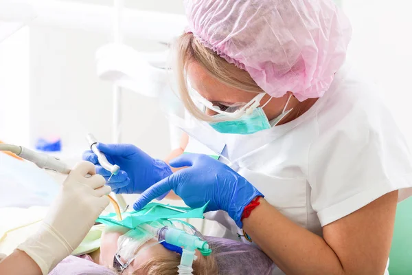 Жіночий стоматолог лікує зуби — стокове фото