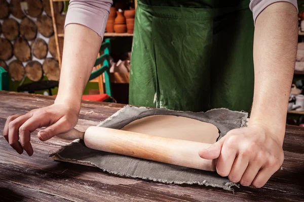 Potter rolls a brown clay — Stock Photo, Image