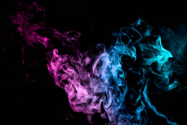 Colorful smoke of blue, pink, green on a black isolated background. Background from the smoke of wipe