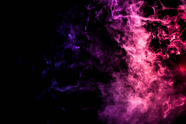Colorful smoke of blue, pink, green on a black isolated background. Background from the smoke of wipe