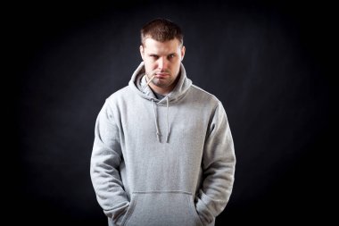 Bir sportif bir genç, siyah saçlı, üzgün görünümlü adam gri sweatshirt bir soğuk ile hasta düştü siyah yalıtılmış zemin sıcaklığı ölçüldü. Bir termometre içinde onun ağız tutan bir adam