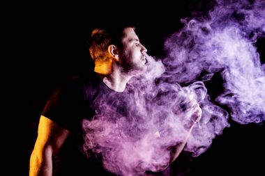 Adam koyu arka plan üzerinde elektronik sigara duman