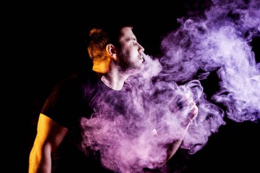 Adam koyu arka plan üzerinde elektronik sigara duman