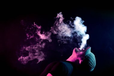 Bir bulut duman kırmızı renk bir siyah renkli bir genç adam nefes verir hepsini geri sarı duman ile kaplıdır renk izole. Genç bir hırsız örneği içinde sigara içmek için zarar