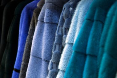 Bir kürk manto üzerinden doğal vizon kürk farklı renkteki bir close-up: gri, mavi, yeşil ve siyah deposunda bir satırındaki asılı