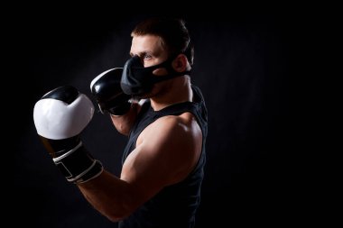 Siyah eğitim maskeli, esmer erkek atlet spor gömlek ve siyah ve beyaz boks siyah bir izole arka planda boks eldivenleri