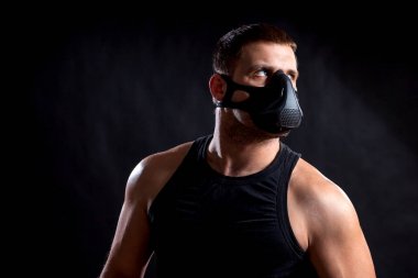 Esmer adam atlet siyah eğitim maskeli ikindilerde bir ihbarı arıyorsunuz bir spor gömlek arka plan izole.