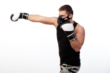 Genç erkek atlet eğitim maskeli spor gömlek ve boks eldiven kutusunda beyaz bir arka plan izole.