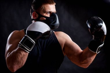  Spor gömlek, eğitim maskesi ve boks eldiven yalıtılmış siyah arka plan üzerine delme için hazır giyen genç atletik erkek portresi 