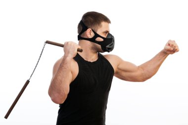 Atletik delikanlı bir spor gömlek, eğitim siyah maske bir nunchaks bir beyaz izole arka plan üzerinde tutar