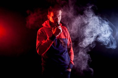 Mod tutan bir buharlı adam. Bir buhar bulutu. Siyah arkaplan.