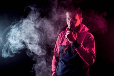 Mod tutan bir buharlı adam. Bir buhar bulutu. Siyah arkaplan.