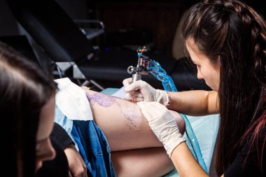 Bir kadın portresi dövme lamba ışığı altında uyluk üzerinde bir işlemi oluşturma dövme gösteren ana.