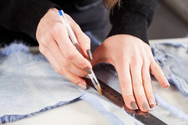 毛皮商人の若い女性のクローズ アップは女性の毛皮のコートを作るため青い毛皮の帽子を塗る — ストック写真