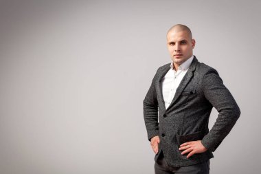 Genç kel adam beyaz gömlekli, gri takım güvenle kamera ve beyaz izole arka plan üzerinde poz bakar