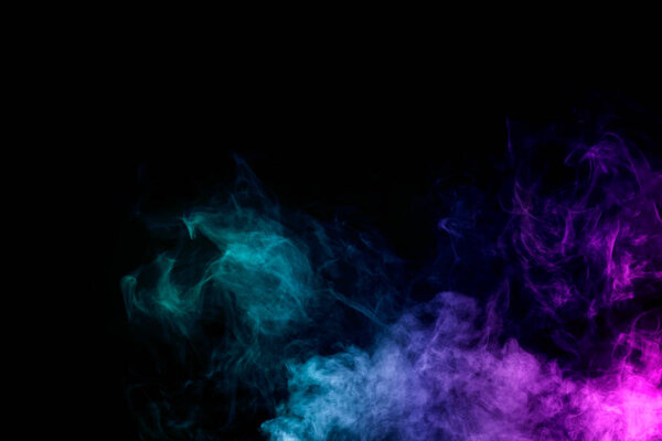 Dense multicolored smoke of red, purple and pink colors on a black isolated background. Background of smoke vape