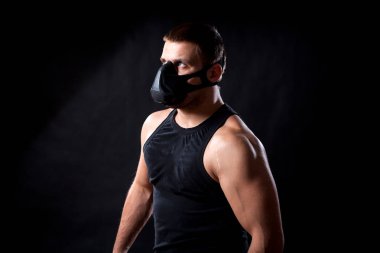 Esmer adam atlet siyah eğitim maskeli ikindilerde bir ihbarı arıyorsunuz bir spor gömlek arka plan izole.