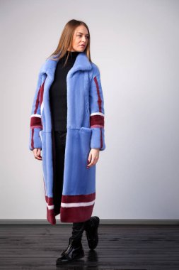 Doğal vizon kürk bordo renkli beyaz çizgili uzakta beyaz izole arka plan üzerinde seyir ile yapılan Mavi kürk ceket genç esmer kadın