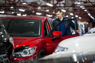 Genç başarılı biri kendisi yeni bir araba kırmızı crossover motor Show'da alır