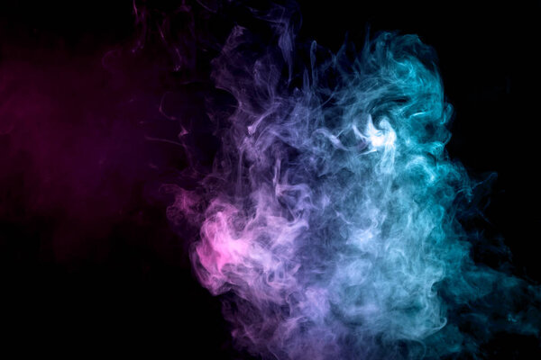 Thick colorful smoke of green on a black isolated background. Background from the smoke of vape